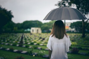 woman with umbrella at a cemetery
