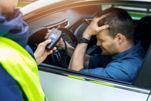 drunk man taking breathalyzer