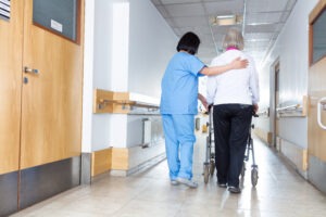 woman walking with nurse in nursing home
