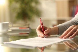 woman’s hand signing document