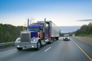 car coming up alongside 18-wheeler