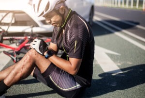 man on the ground after a car and bike crash