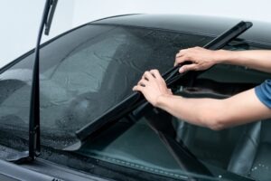 auto worker unrolling car window tint