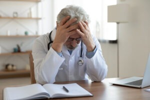 distressed-doctor-at-desk