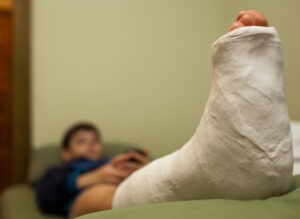 boy with leg in cast propped up