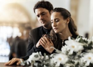 man comforting woman at funeral