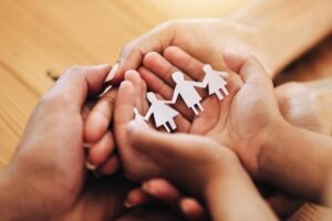 person holding family of paper dolls